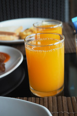 orange juice in glass on wooden table