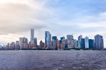 Obraz premium Pejzaż finansowej dzielnicy Manhattanu z Liberty Island, w mglisty dzień.