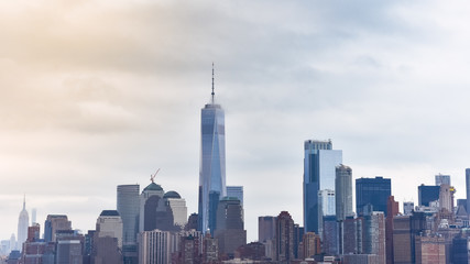 Fototapeta premium Pejzaż finansowej dzielnicy Manhattanu z Liberty Island, w mglisty dzień.