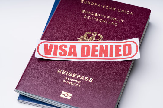 Visa Denied Text With Passports Over White Backdrop