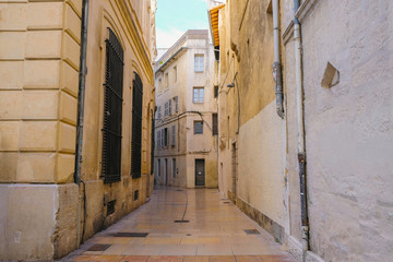 Fototapeta na wymiar Empty stone street of old town in Avignon. Tourism in France.