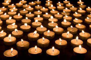 Large group of burning candles at a black background