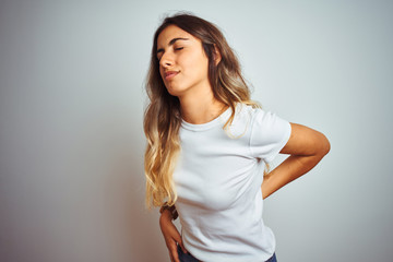 Young beautiful woman wearing casual white t-shirt over isolated background Suffering of backache, touching back with hand, muscular pain