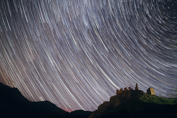 Star trails at night over an abandoned castle in Coltesti, Romania