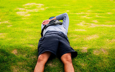 The young man was lying on the lawn in a dismal day