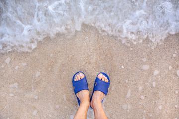 Fototapeta premium Abstract Man foot with shoe walk on soft sand at the beach with waves. Illustration in a comfortable vacation by the sea.