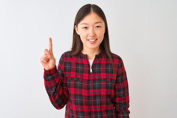 Young chinese woman wearing casual jacket standing over isolated white background showing and pointing up with finger number one while smiling confident and happy.