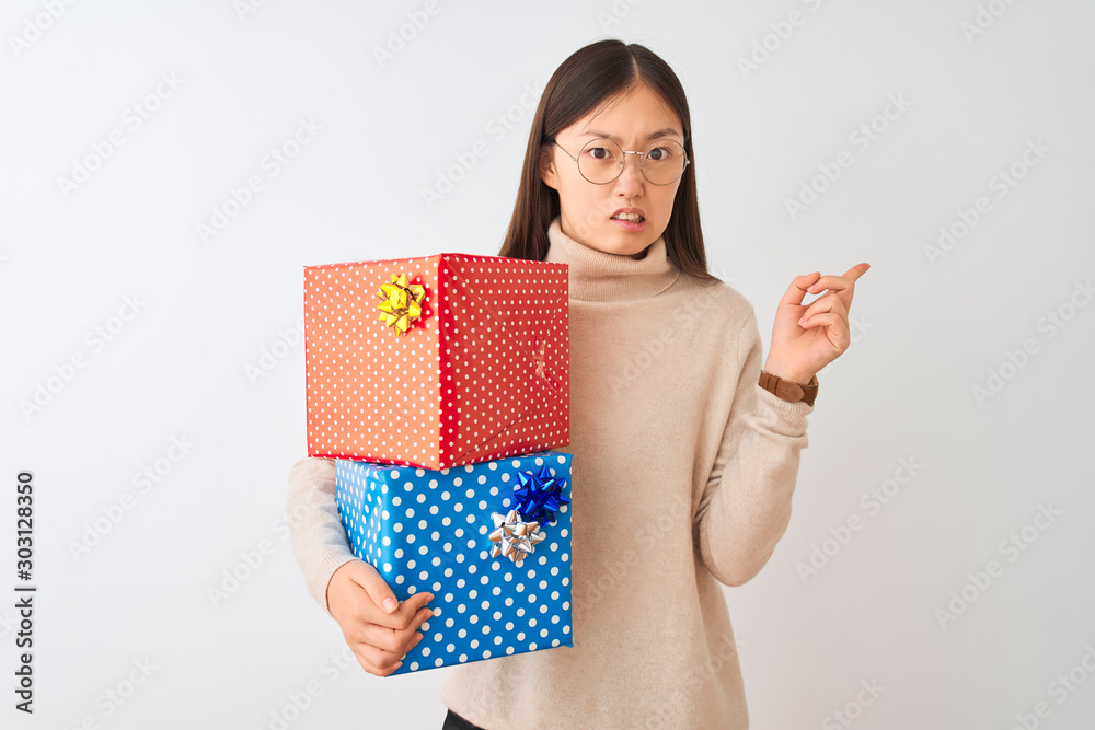 Sticker Young chinese woman holding birthday gifts over isolated white background Pointing aside worried and nervous with forefinger, concerned and surprised expression