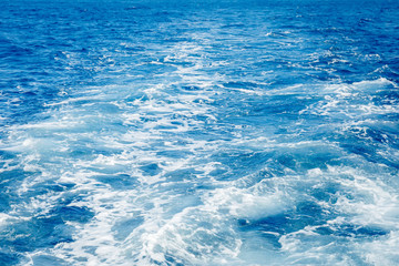 Blue sea surface background with splashing waves