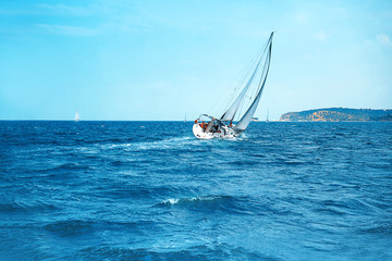 Sailing yacht race with white sails at opened sea.