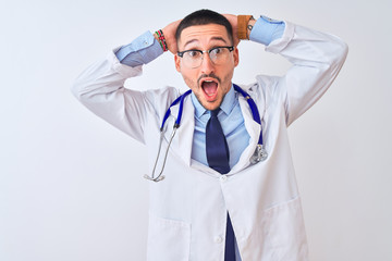Fototapeta premium Young doctor man wearing stethoscope over isolated background Crazy and scared with hands on head, afraid and surprised of shock with open mouth