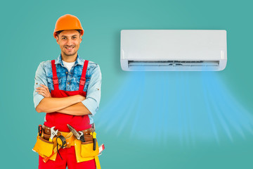 Male technician posing near air conditioner indoors