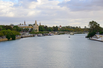 Fototapeta premium Seville, Spain - November 5, 2019: Alfonso XIII Canal and Torre del Oro in the background in Seville.