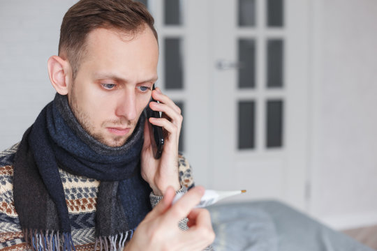 Sick man calling by phone sitting at home.