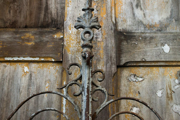Detail of an iron gate in front of a wooden door