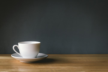cup of coffee on wooden table with grey background
