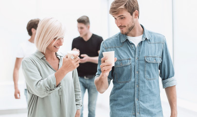 Fototapeta premium employees with coffee glasses passing through the corridor of the office