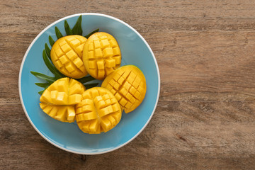 Mango fruits on a blue plate. Top view. Free space for text.