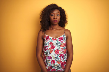 African american woman wearing floral summer t-shirt over isolated yellow background depressed and worry for distress, crying angry and afraid. Sad expression.