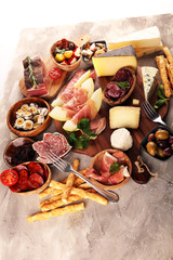 Italian antipasti wine snacks set. Cheese variety, Mediterranean olives, seafood salad, Prosciutto di Parma, tomatoes, anchovy and wine in glasses