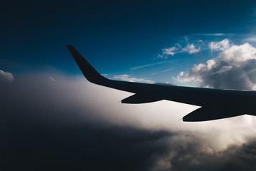 Fototapeta na wymiar Silhouette of an airplane wing in clouds. 
