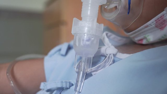 Closeup Sick Asian Girl Wearing Oxygen Respiratory Mask For Disease Treatment In Hospital Bed, Healthcare Medical, Tilt Up  