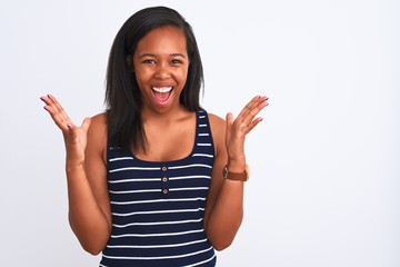 Beautiful young african american woman wearing summer t-shirt over isolated background celebrating crazy and amazed for success with arms raised and open eyes screaming excited. Winner concept