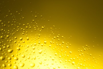 Yellow oil bubbles on water, cooking oil background.
