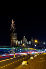 Fototapeta na wymiar A cathedral and light trails of a train and cars in Amsterdam 