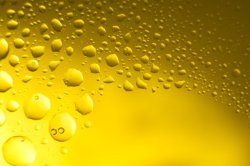 Yellow oil bubbles on water, cooking oil background.