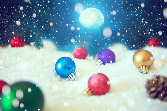 Christmas background with Christmas balls on snow over fir-tree, night sky and moon. Shallow depth of field. The elements of this image furnished by NASA