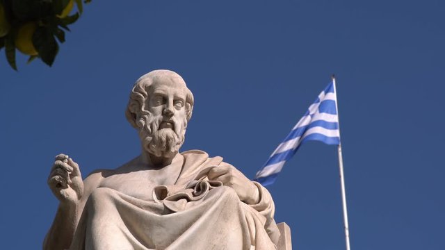 Statue of the Greek philosopher Plato, Greek flag on the background