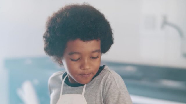 Young family cooking food in kitchen. Happy Little girl with her mother mixing batter. Mother and Little boy preparing the dough. Happy family in the kitchen and junior chef Concept. Cinematic 4k.