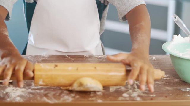 Young family cooking food in kitchen. Happy Little girl with her mother mixing batter. Mother and Little boy preparing the dough. Happy family in the kitchen and junior chef Concept. Cinematic 4k.