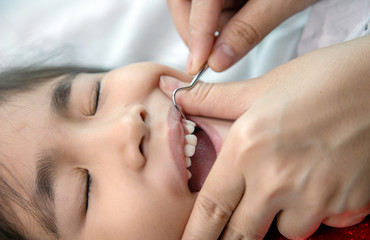 Obraz na płótnie Canvas close up dentist cleaning teeth of asian kids