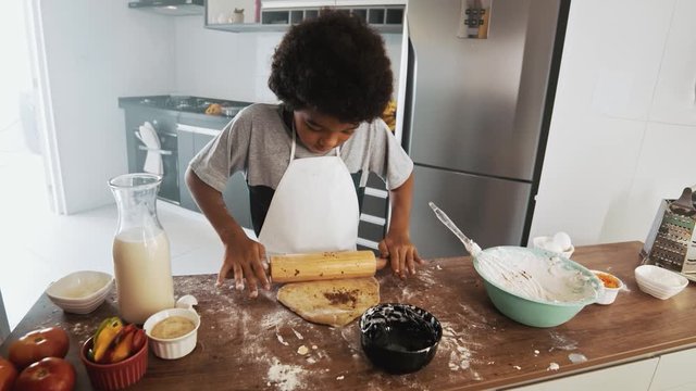 Young family cooking food in kitchen. Happy Little girl with her mother mixing batter. Mother and Little boy preparing the dough. Happy family in the kitchen and junior chef Concept. Cinematic 4k.