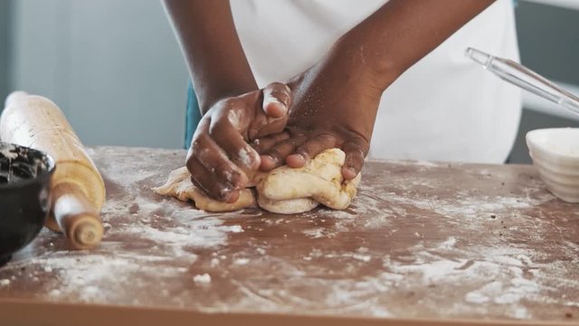 Young family cooking food in kitchen. Happy Little girl with her mother mixing batter. Mother and Little boy preparing the dough. Happy family in the kitchen and junior chef Concept. Cinematic 4k.