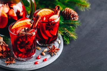 Christmas sangria or mulled wine with apples, oranges, pomegranate and cinnamon sticks.
