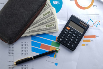 Financial reports on the table, business attributes, pen and calculator with banknotes in the wallet. Business growth concept background for business and money