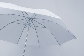 Bottom view of open white umbrella on white background