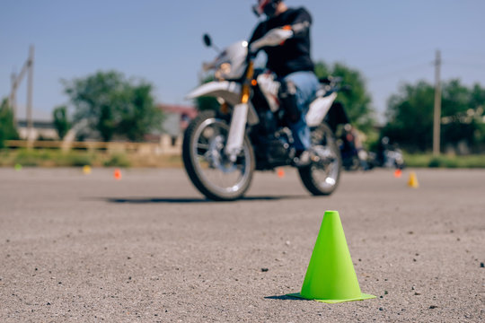 Green cone close-up on the site for bikers.  Traffic cones on the training ground in the driving school. Circuit for students in a motorcycle school.  Motorcycle driving courses