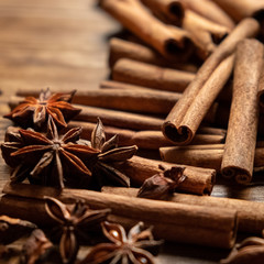 Obraz na płótnie Canvas Star anise, cinnamon. Aromatic spices on wooden background. Top view. Close up. Seasoning ingredients for cooking or baking. Selective focus