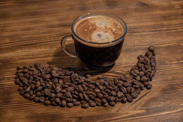 Coffee cup and coffee beans on wooden table. Selective focus