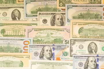 Banknotes of one hundred dollars and another denomination, lie in neat rows as a background. Business concept