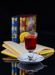 tea with lemon on the background of an open book