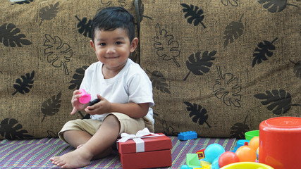 Naklejka premium Cute happy & curious little Asian 1.6 year / 18 months old toddler baby boy child sitting in the beautiful cafe relax time on holiday Kid experience & discovery concept.