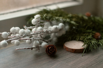 Obraz na płótnie Canvas Decorative Christmas decor from snow branches, cones, Christmas trees on a wooden background