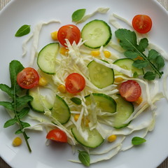Fresh and healthy vegetable salad with cabbage, tomatoes, cucumbers, corn and arugula. View from above.