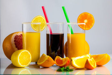 a glass of orange juice with a straw and orange