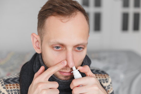 Man use nasal spray. concept of treatment for allergies or the common cold, winter style.